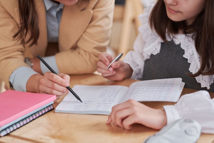 teacher teaching a lesson to her student 
